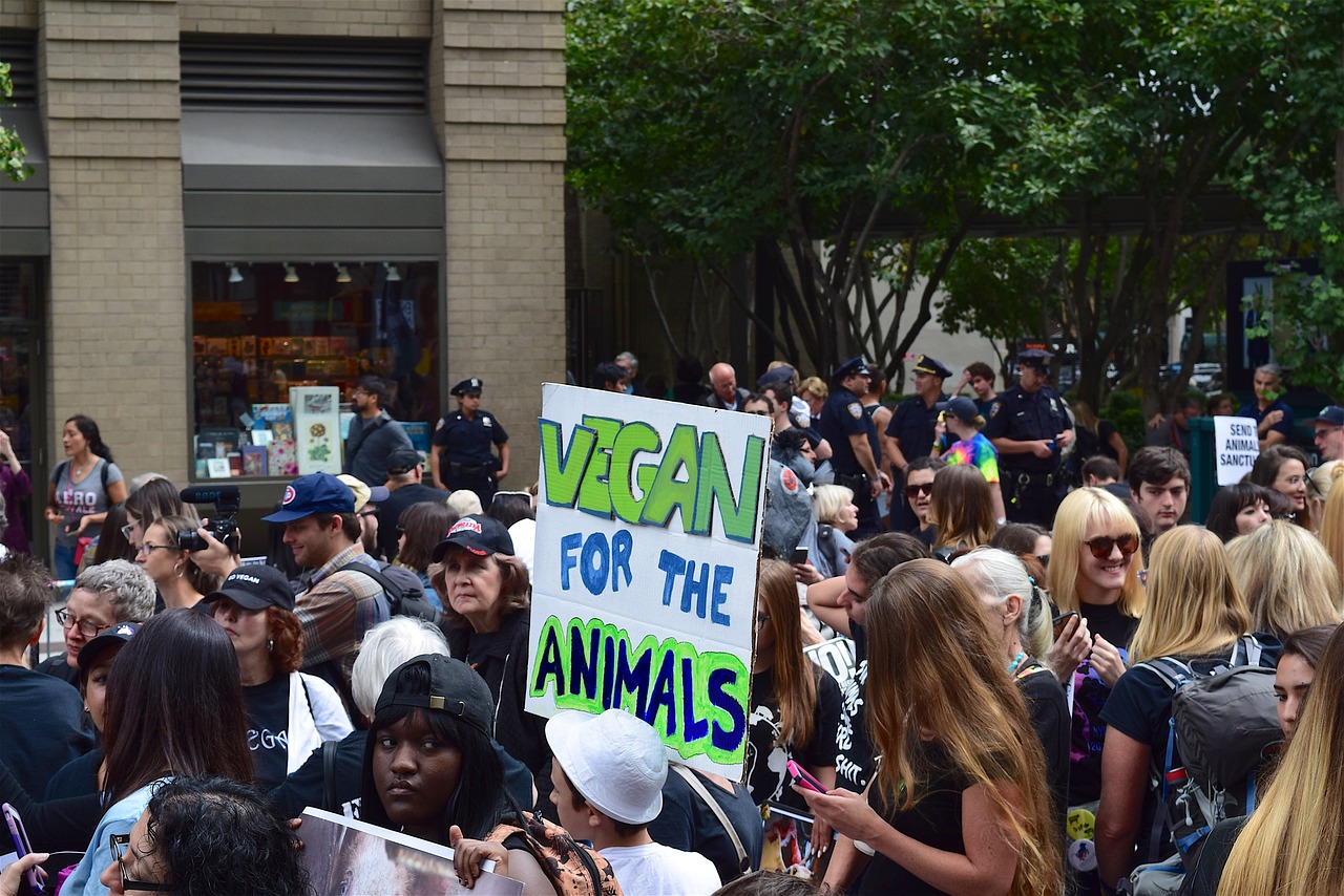 rally with a sign reading vegan for the animals
